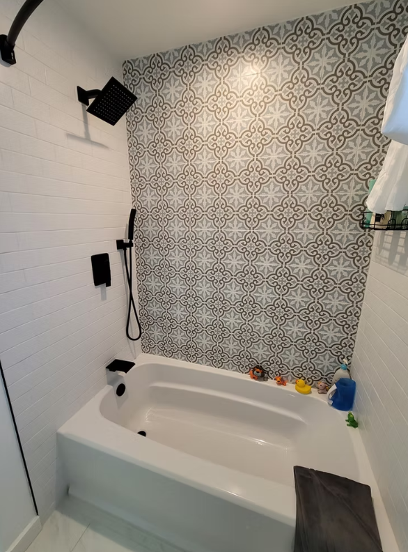 Bathroom remodel with walk-in shower featuring concrete-look panels and black niche, installed for a homeowner in Kirkland