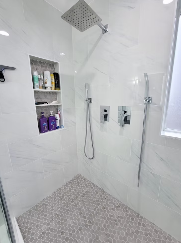Walk-in shower interior with built-in shelving and hex floor tile, installed for a homeowner in Kirkland