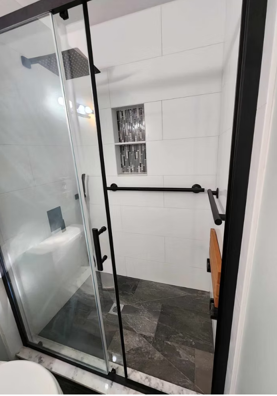 Close-up shower detail with hex accent tile and rain shower head, installed for a homeowner in Marysville